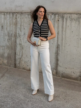 A woman wears striped cardigan and jeans